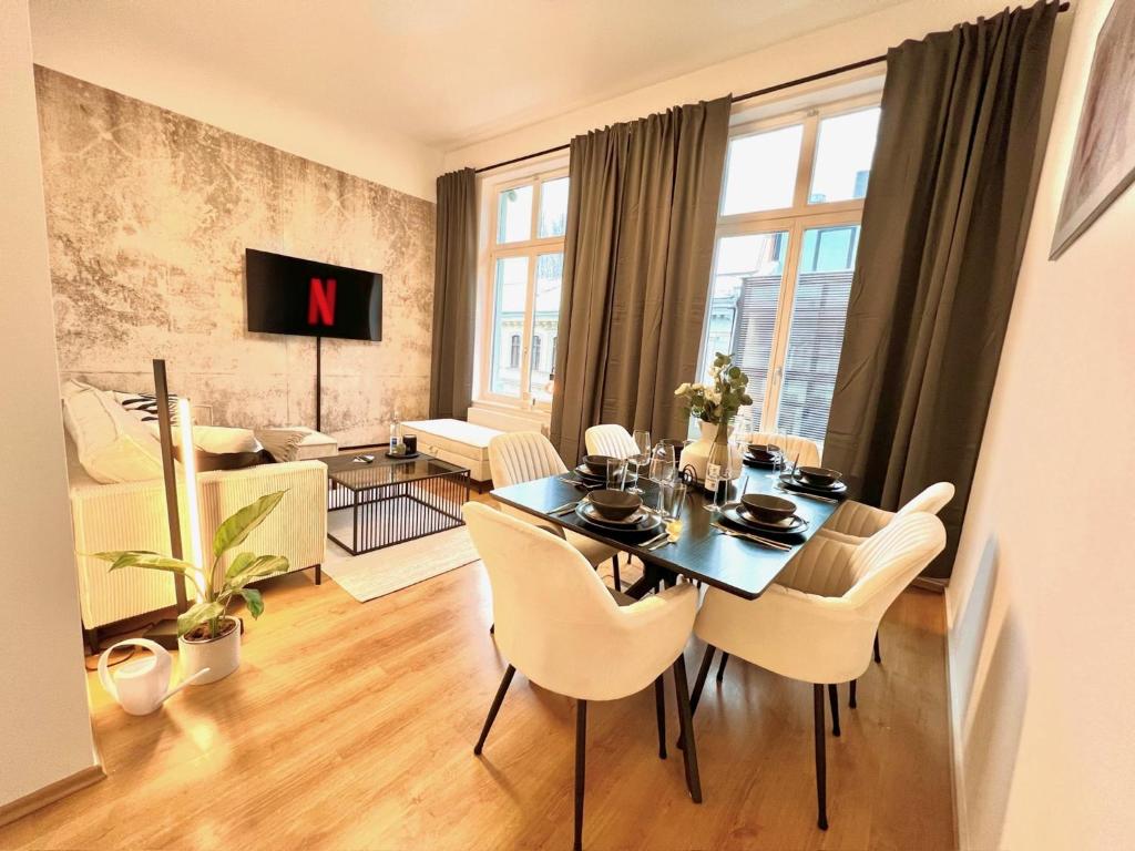 een eetkamer met een tafel en stoelen in een woonkamer bij LE Vacation 3-Room-City-Apartment, Küche, Neflix, Free TV in Leipzig