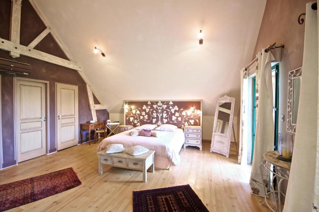 a bedroom with a large bed with a headboard at Entre Vignes et Châteaux in Fougères-sur-Bièvre