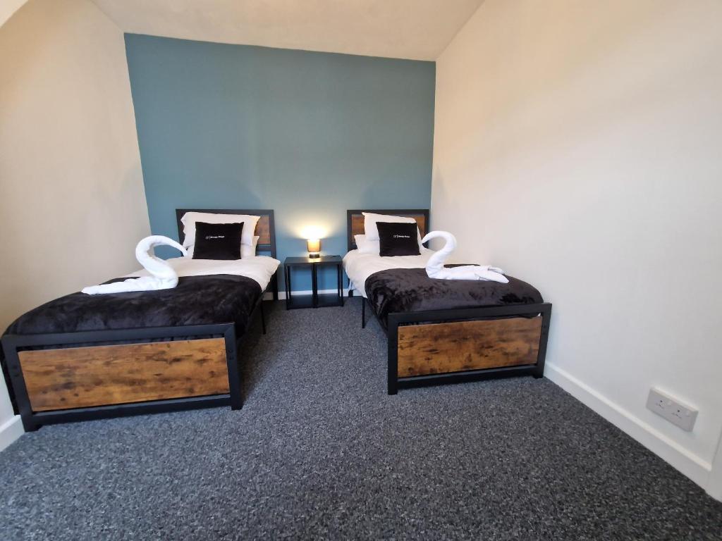a room with two beds in a room at 3 bedroom Urban Retreat Near Bike Park Wales in Merthyr Tydfil