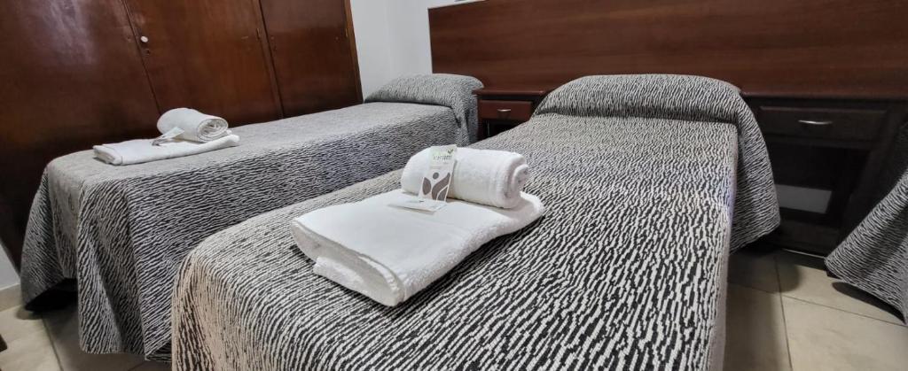 2 Betten mit Handtüchern auf einem Zimmer in der Unterkunft Hotel Bertiami in Mar del Plata