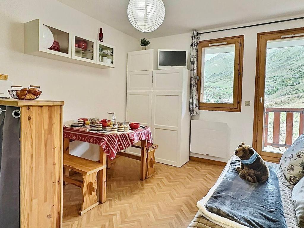 un salon avec une table et un chien assis sur un canapé dans l'établissement Studio cabine 4 pers à Tignes, pied des pistes, proche commerces, balcon au sud, bien équipé - FR-1-411-486, à Tignes
