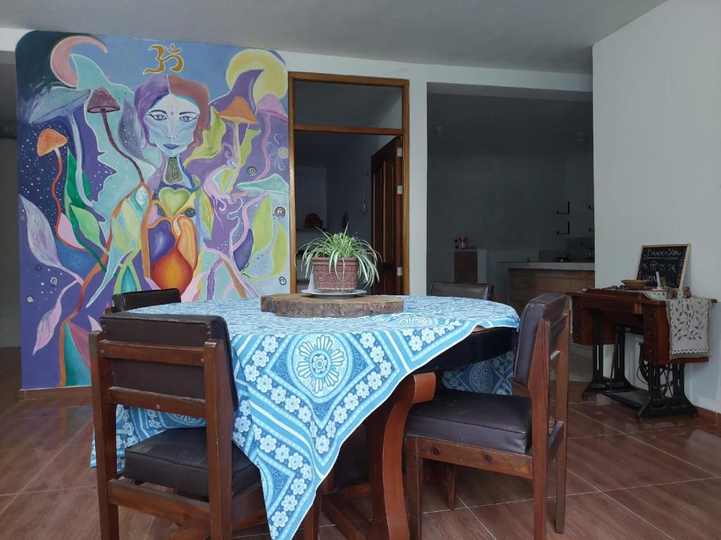 una mesa con sillas y una pintura en la pared en Casa de Viole, en Moyobamba