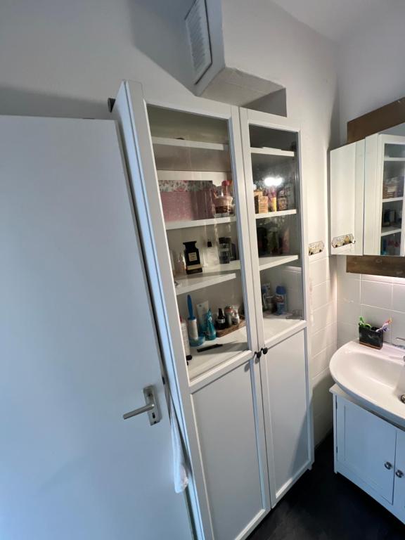 La salle de bains est pourvue d'un évier et d'un réfrigérateur blanc. dans l'établissement Schlafzimmer der Stille2, à Bochum