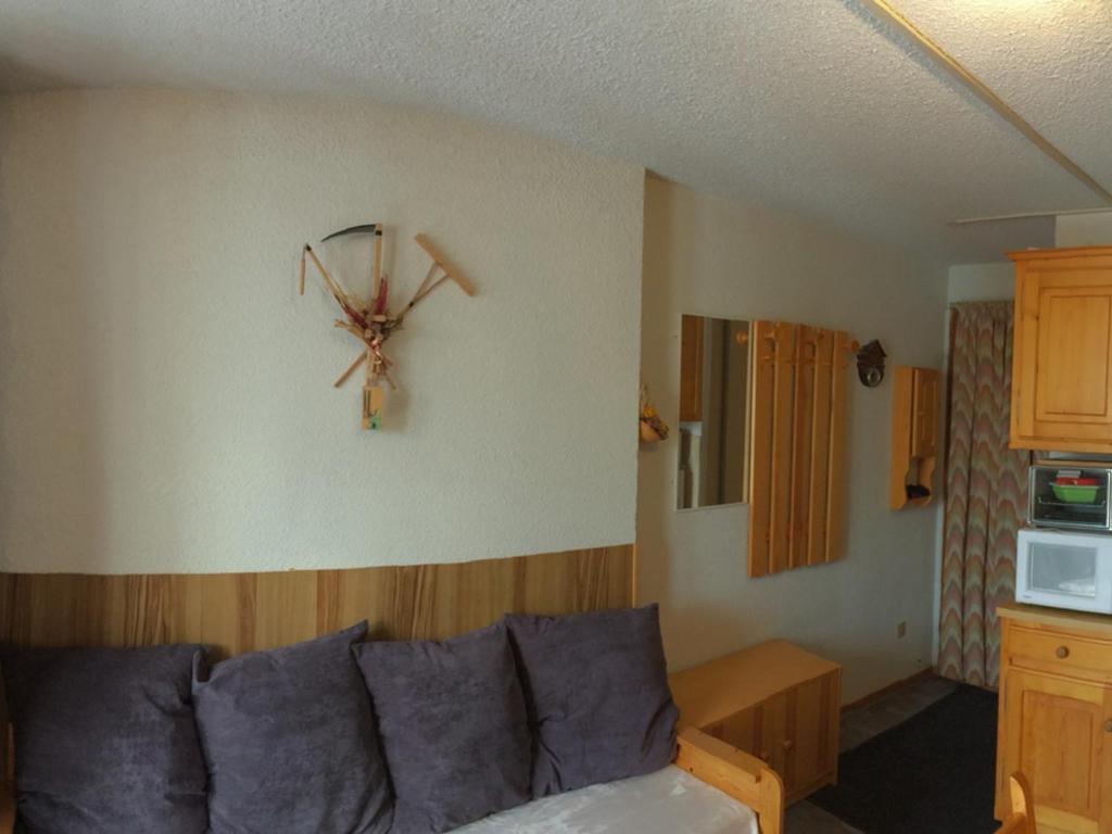 un salon avec un canapé et une horloge au mur dans l'établissement Studio 4 pers., pied des télésièges, balcon sud, calme, proche commerces - FR-1-416-66, à La Toussuire