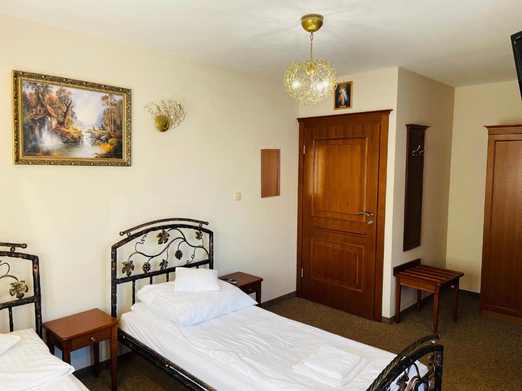 um quarto com duas camas e uma foto na parede em Pokoje noclegowe KASZTEL - Łowisko em Łowisko