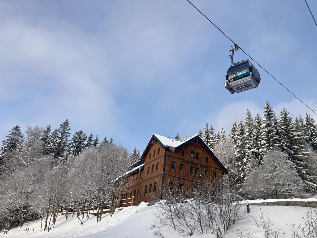 揚斯凱拉茲涅的住宿－Ludvíkova bouda，雪中飞过建筑物的滑雪缆车