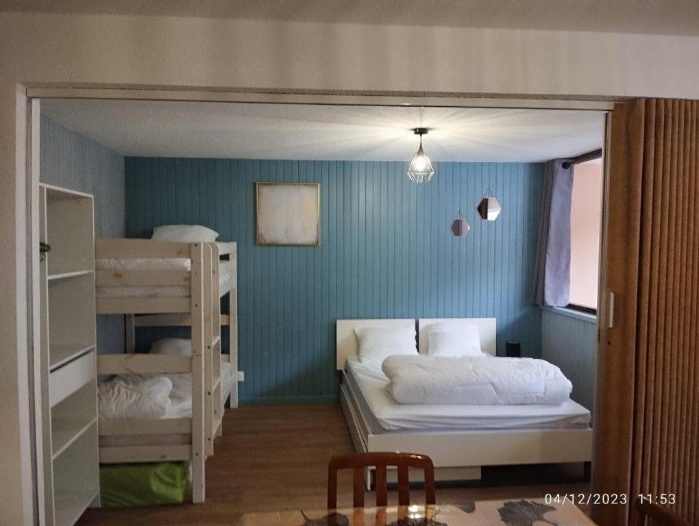 a small room with two bunk beds and a table at Proches des pistes F2 36m2 4-6 pers 2 étoiles in Besse-et-Saint-Anastaise