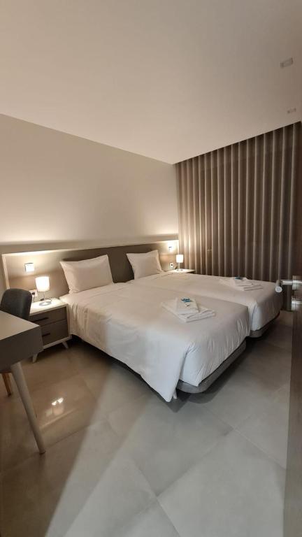 een slaapkamer met een groot wit bed en een bureau bij Up Sal in Aveiro