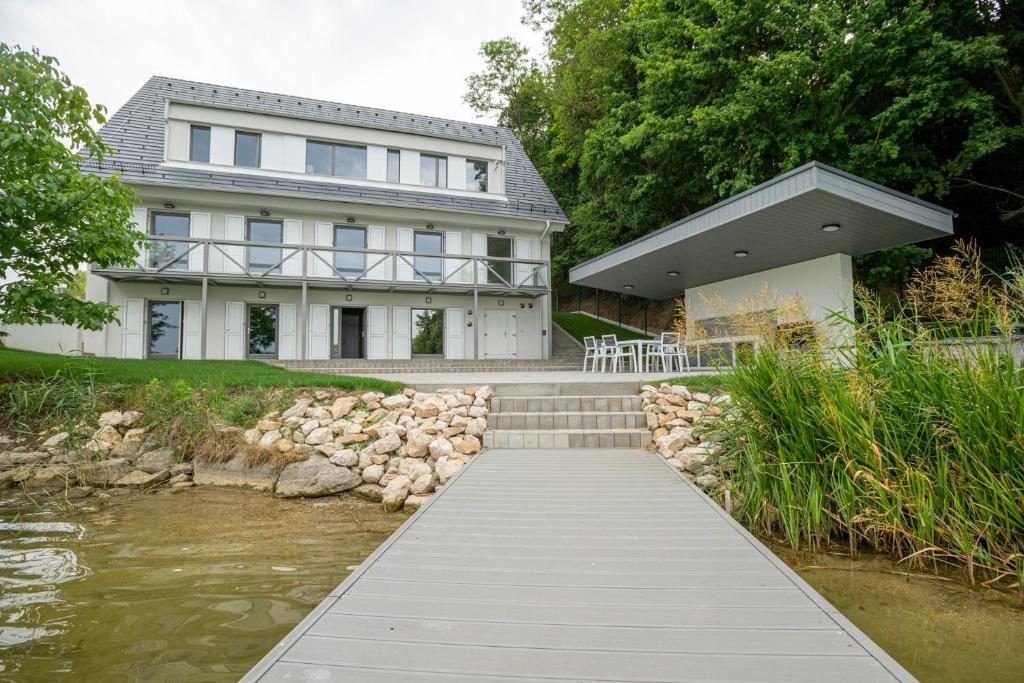 una casa blanca con un puente sobre un río en Gátőr Villa, en Mőcsény