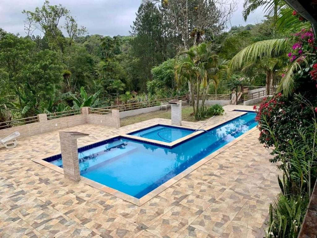 une image d'une piscine dans un complexe dans l'établissement Chácara Recanto dos pássaros, à Bairro das Rosas