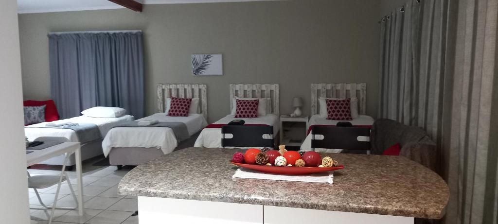a hospital room with beds and a bowl of fruit on a counter at DeLutz Overnight Room 3 in Polokwane