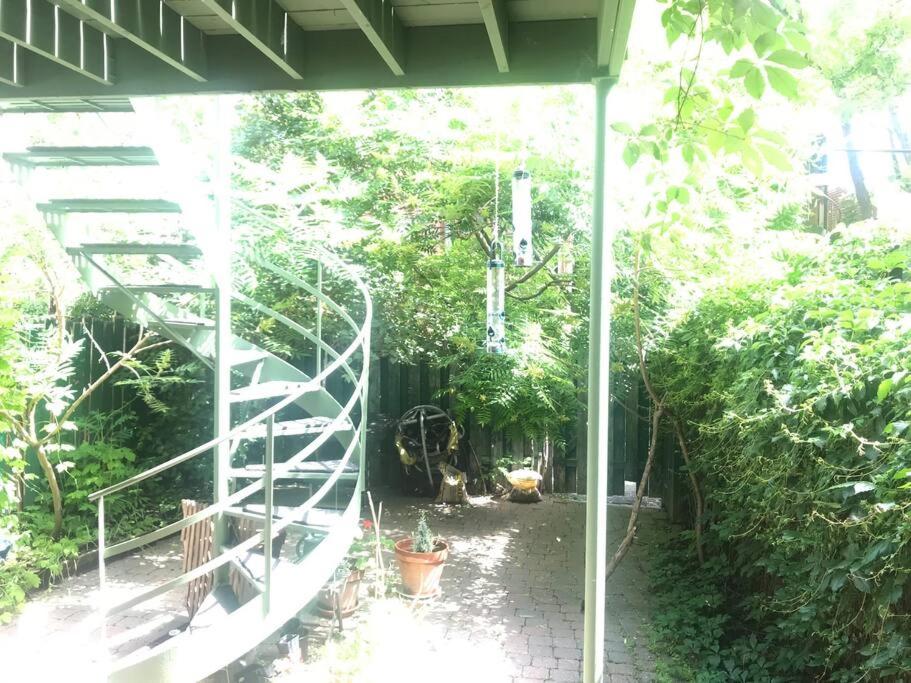un escalier en colimaçon dans un jardin orné de plantes dans l'établissement Quiet cozy apartment with A/C, backyard, Netflix, à Montréal