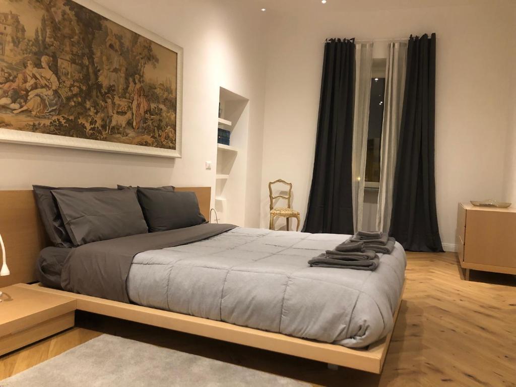 1 dormitorio con 1 cama y una gran pintura en la pared en sonnino house, en Pisa