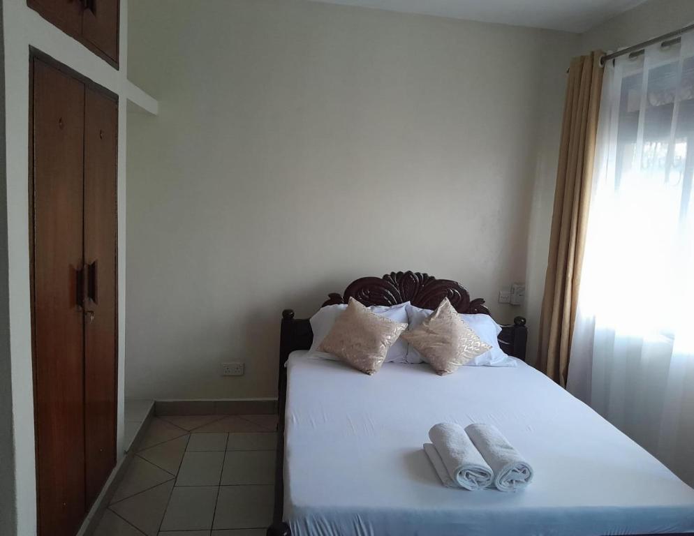 1 dormitorio con 1 cama con 2 toallas en Galene Abode Studio Apartment, Nyali en Mombasa