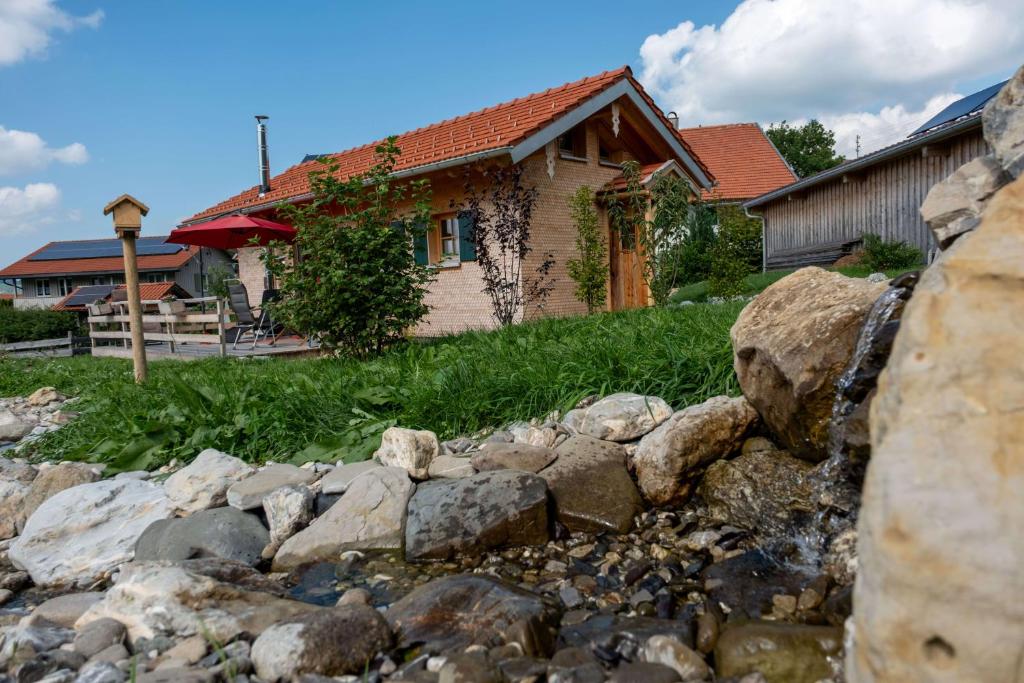 une maison avec un tas de rochers devant une maison dans l'établissement Tinyhouse Momente Chalet als Rückzugsort für Naturliebhaber im Oberallgäu, à Wertach