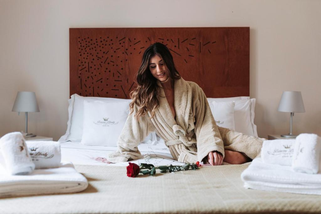 uma mulher está sentada numa cama em B&B Barone Liberty & Luxury SPA em Gallipoli