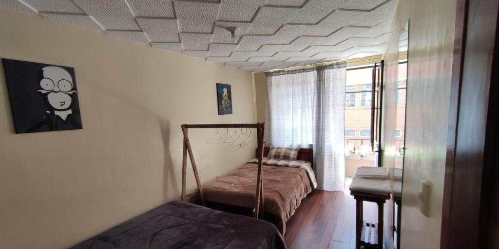 a bedroom with two beds in a room with a window at Hakuna Matata in Cuenca