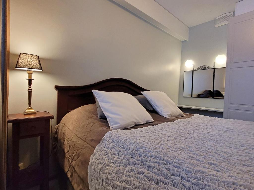 sypialnia z łóżkiem z 2 poduszkami i lampką w obiekcie Apartments Golf w mieście Tahkovuori