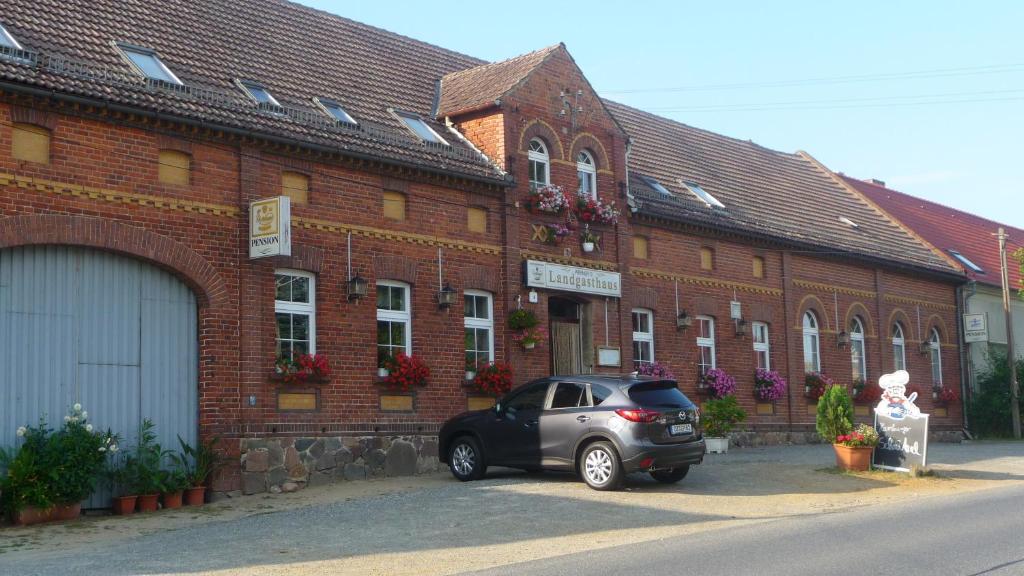 un coche aparcado frente a un edificio de ladrillo en Werners Landgasthaus en Lieskau