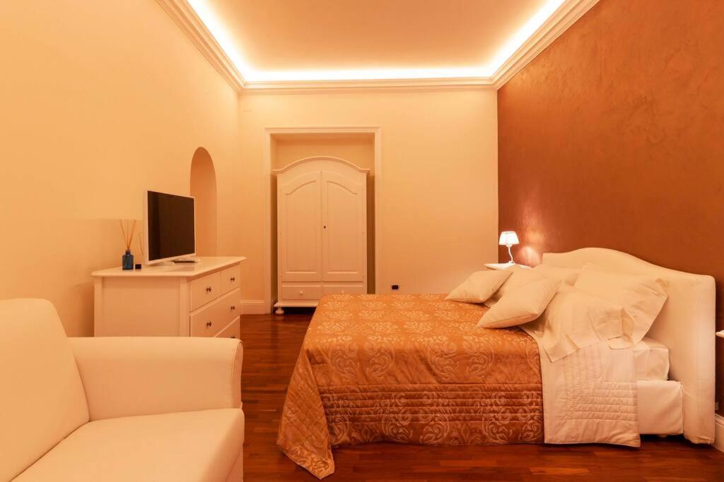 a bedroom with a bed and a white couch at Monolocale romantico a Napoli in Naples