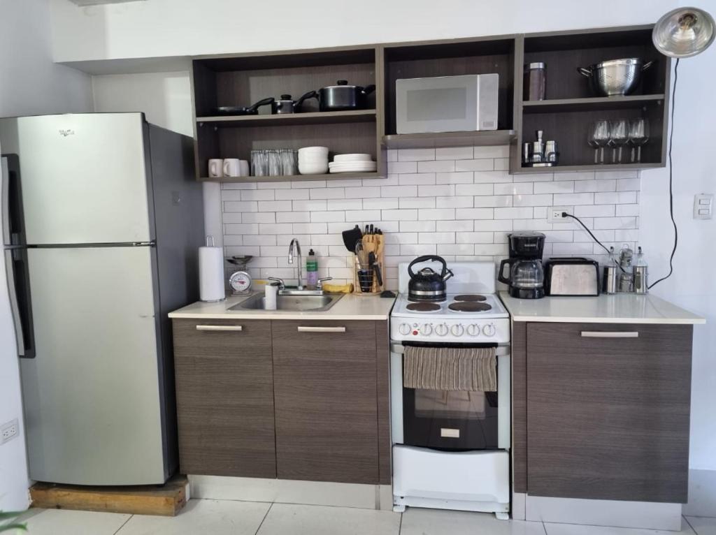 cocina con nevera blanca y fogones en Apartamento tipo Loft, en Guatemala