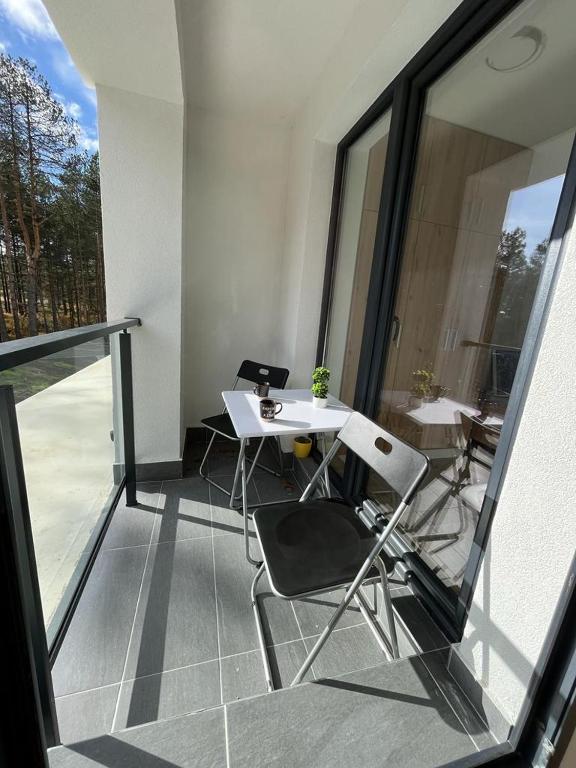 un balcone con tavolo e sedie su un edificio di zeleni bor Divcibare a Divčibare