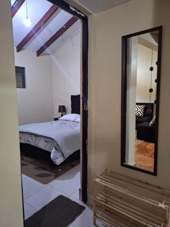 a bedroom with a bed and a mirror at Ttikay Wasi in Cusco