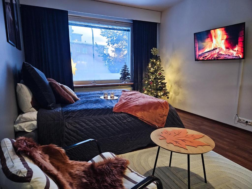 uma sala de estar com uma cama e uma árvore de Natal em Arctic Foxy Studio em Rovaniemi