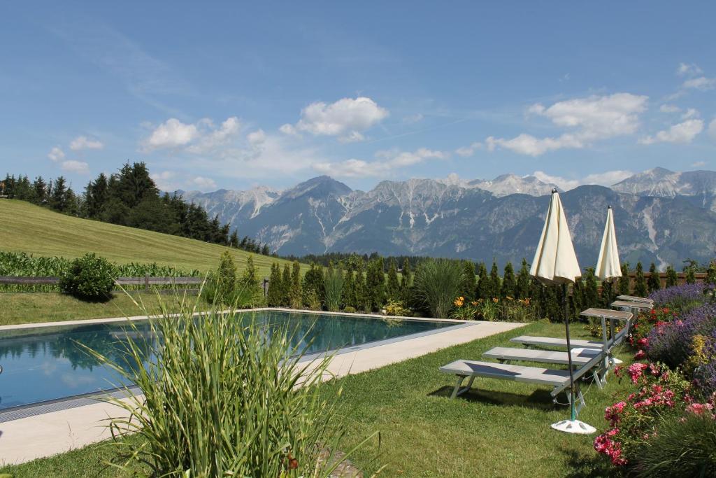 a swimming pool with a view of the mountains at Hotel Geisler Tulfes in Tulfes