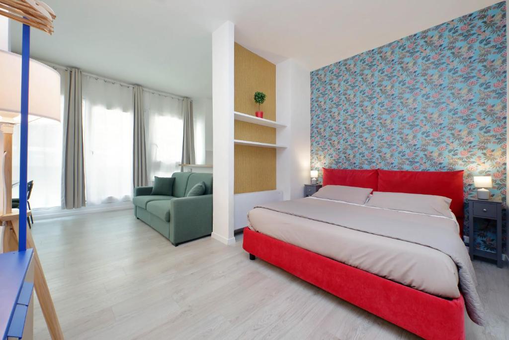 1 dormitorio con 1 cama roja y 1 silla verde en Porta San Giovanni Suite, en Roma