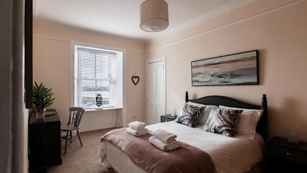 um quarto com uma cama com toalhas em At Anchor (with a Harbour View) em Fife