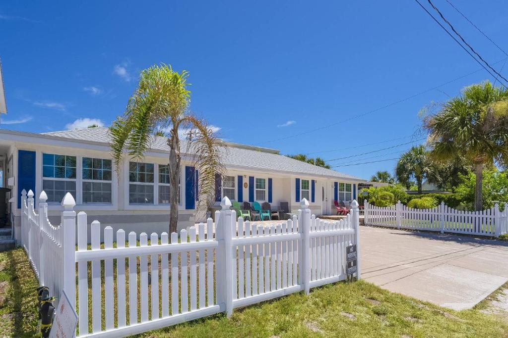 a white picket fence in front of a house at Oceans 13 Unit A in Saint Augustine Beach