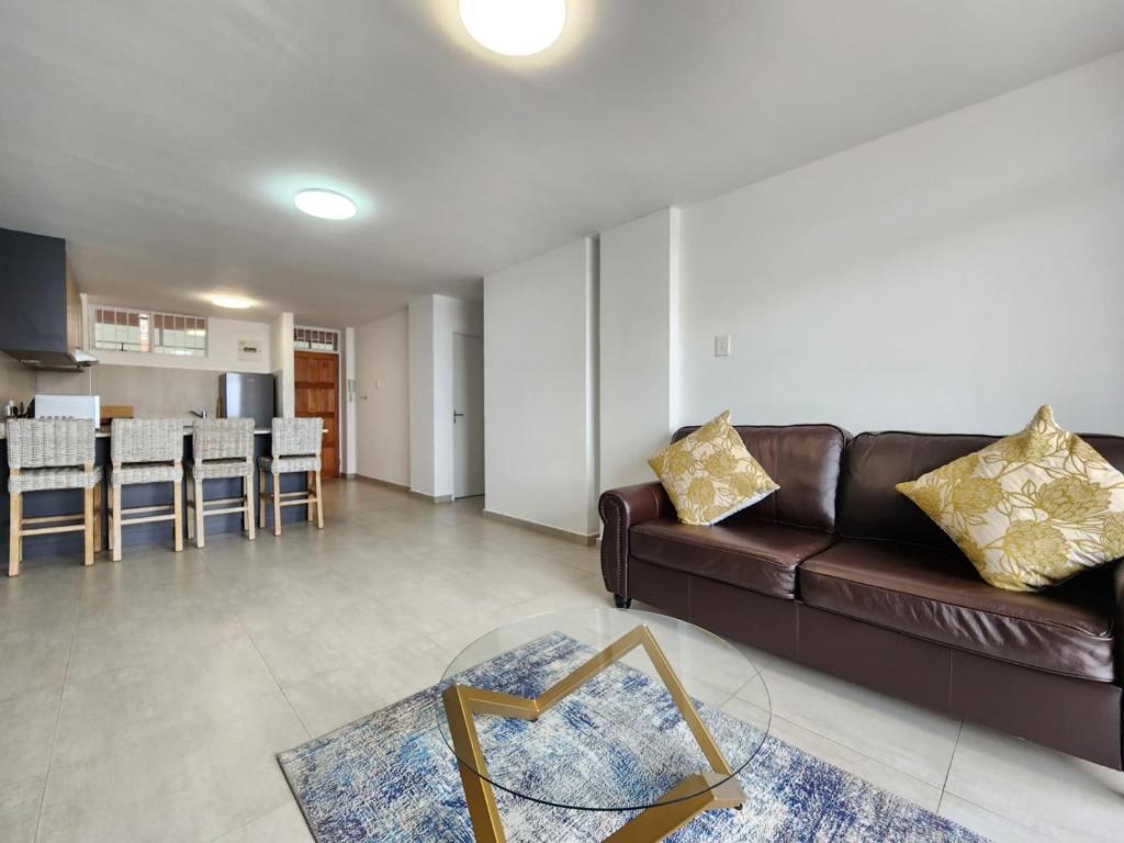 a living room with a couch and a table at Penzance by the beach in Durban