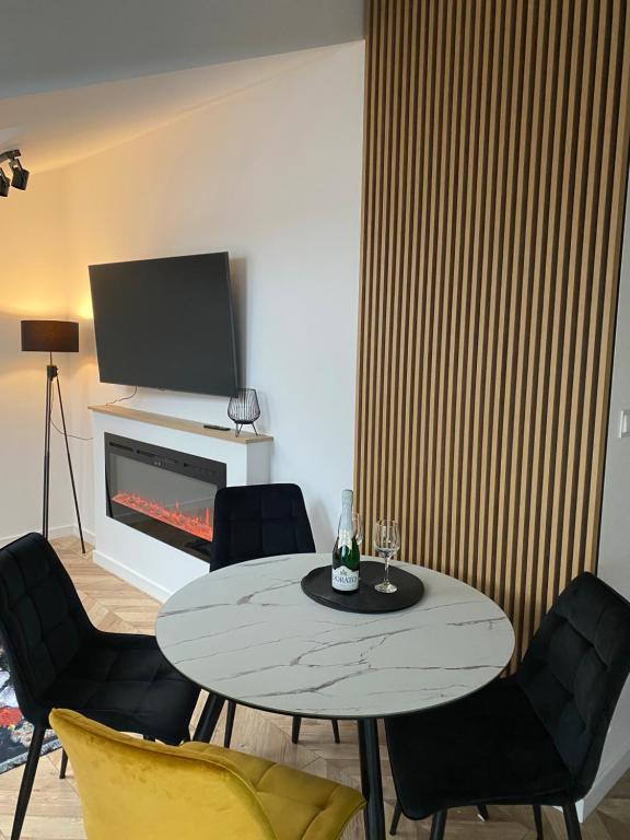 uma sala de estar com uma mesa e cadeiras e uma lareira em Apartament na Spokojnej 24J/16 em Wisla
