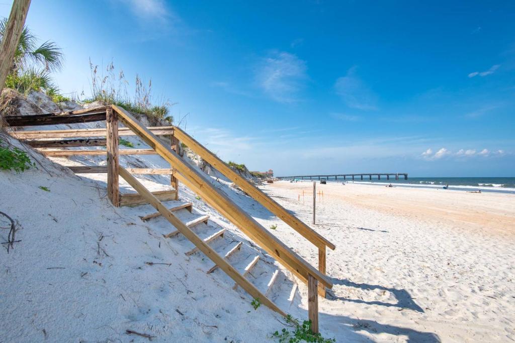 uma escada de madeira que leva até à praia em Oceans 13 Condo D em Saint Augustine Beach