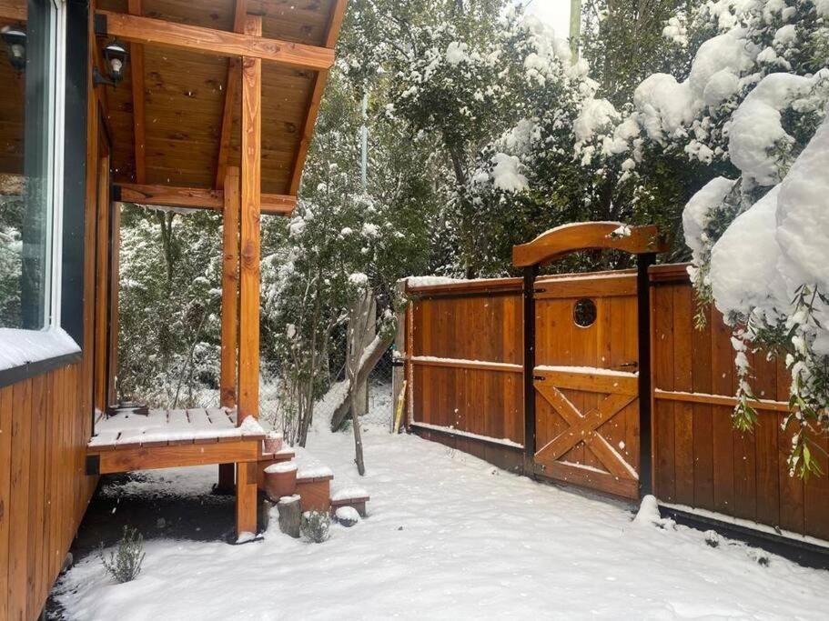 a porch of a cabin with a snow covered door at Estación Ventana - cabaña al pie del cerro in San Carlos de Bariloche