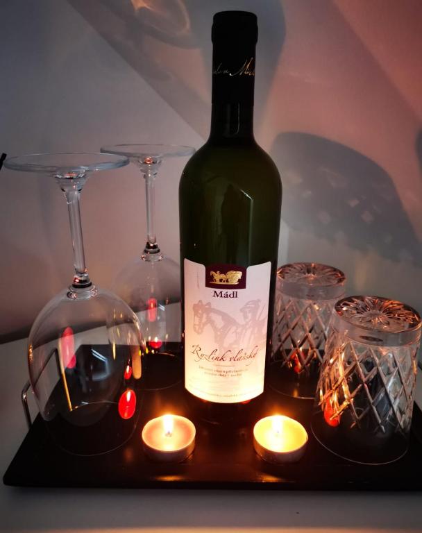uma garrafa de vinho, dois copos e velas em ubytování U NIKY em Hodonín