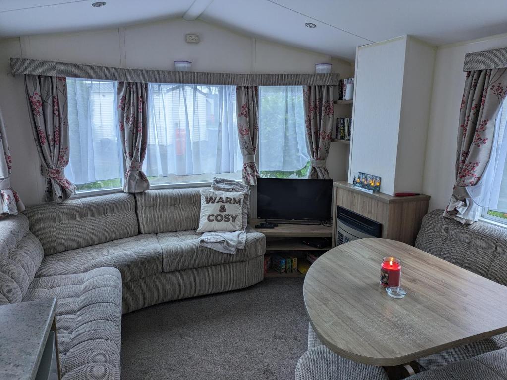 a living room with a couch and a table at The Ocean Pearl caravan number 50 situated on the Cove holiday park in Southwell