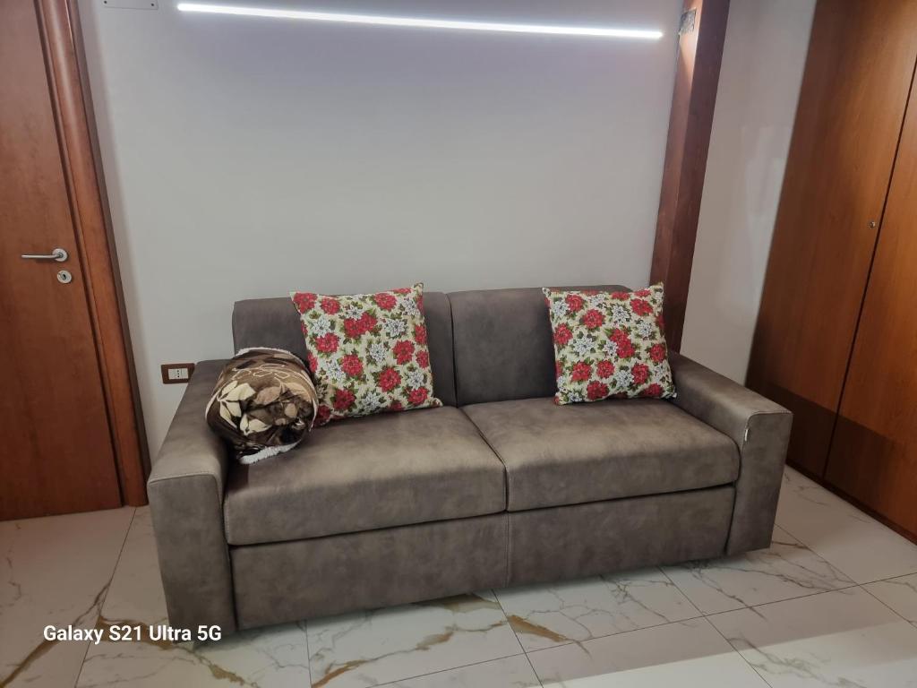 ein Sofa mit zwei Kissen auf einem Zimmer in der Unterkunft San Ciro's Suite in Portici