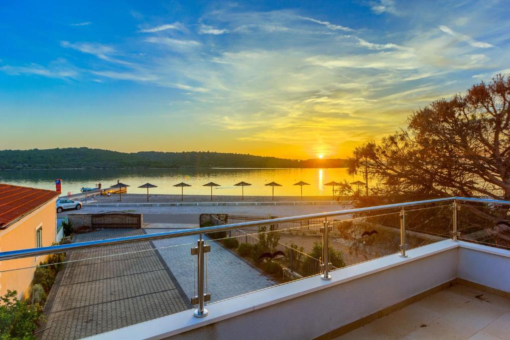 widok na jezioro z balkonu z widokiem na zachód słońca w obiekcie Apartmani Mato w mieście Pirovac