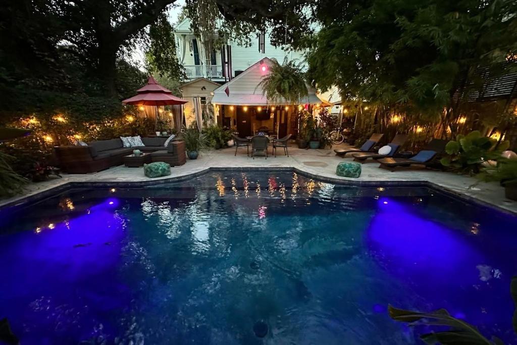 uma piscina com luzes azuis num quintal à noite em The Dragonfly Guest House em Nova Orleans