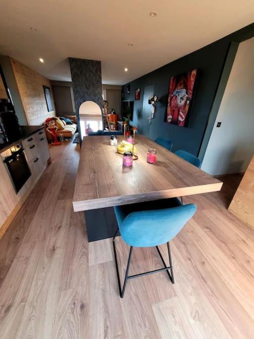uma cozinha com uma mesa de madeira e uma cadeira azul em STRASBOURG em Estrasburgo
