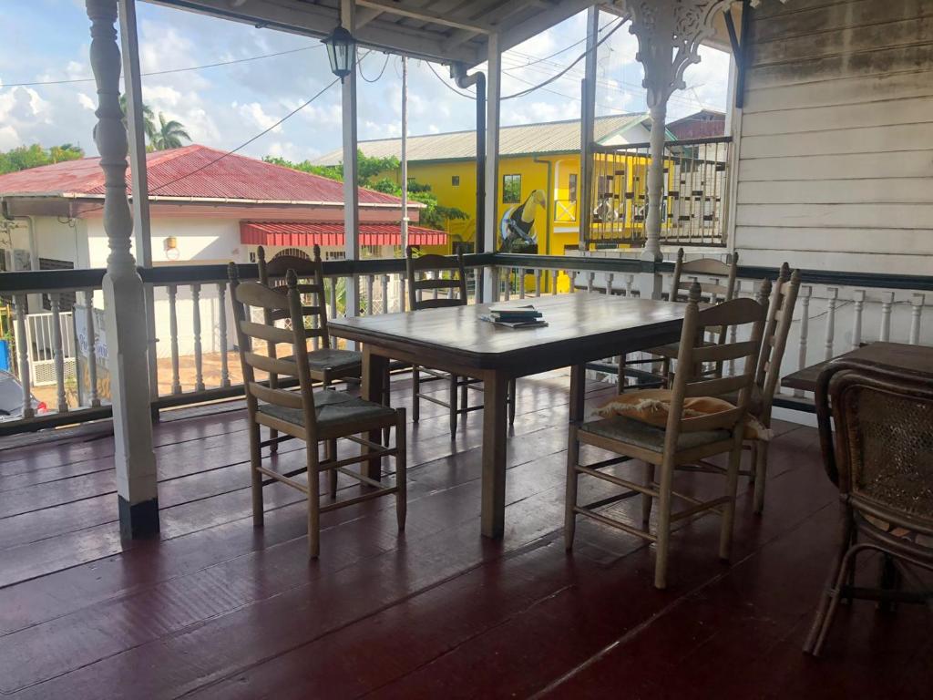 un tavolo e sedie in legno su un portico di Pied a Terre a Paramaribo