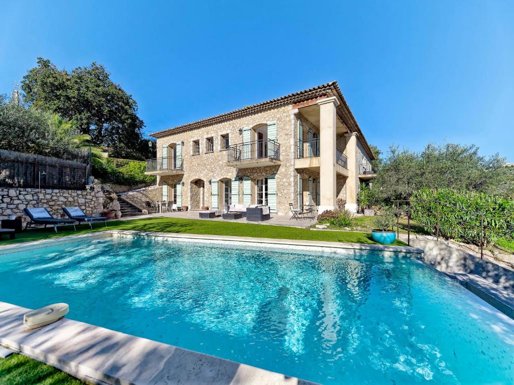 a large swimming pool in front of a house at Bastide d'Architecte en Pierre in Cagnes-sur-Mer