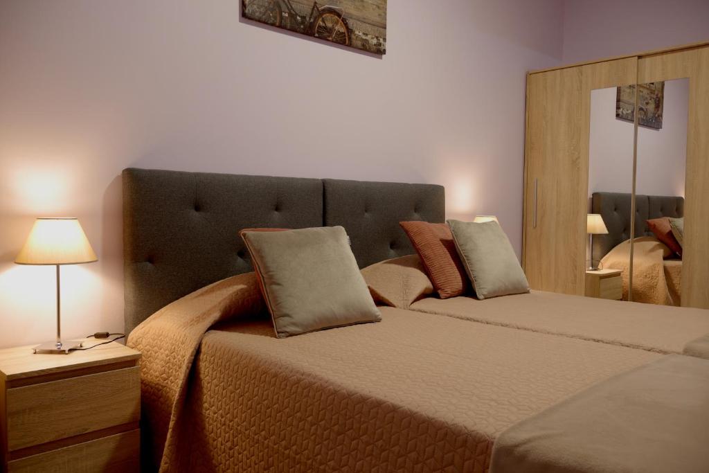 1 dormitorio con 2 camas, lámpara y espejo en Village Center Two Bedroom Apartment en Porto Moniz