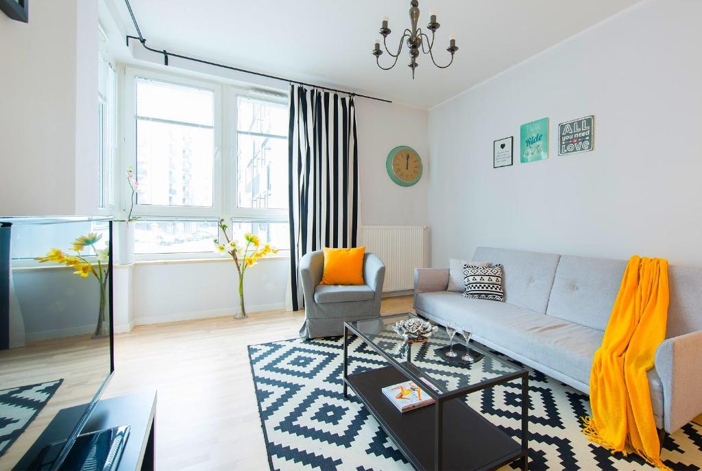 uma sala de estar com um sofá e uma mesa em Apartment 1-bed Kłobucka P&O Serviced Apartments em Varsóvia