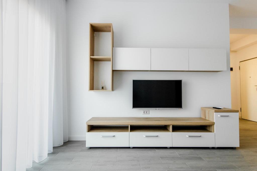 a living room with a tv on a white wall at Samplus Central Apartment in Craiova