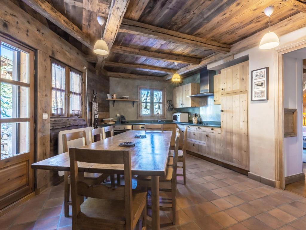 una grande cucina con tavolo e sedie in legno di Chalet 5* à Courchevel Village, proche pistes, 4 chambres, cheminée, jacuzzi, garage, Wi-Fi inclus - FR-1-562-40 a Courchevel