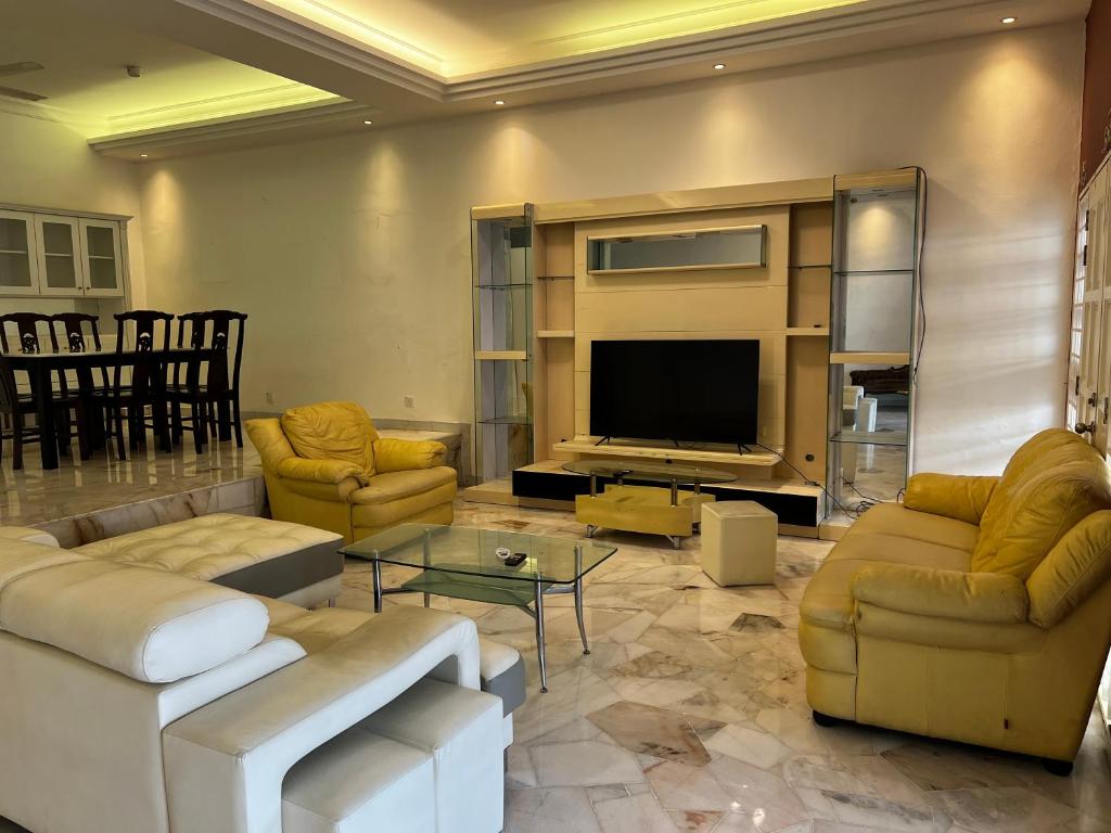 a living room with couches and a flat screen tv at Prime Villa in Kuala Lumpur