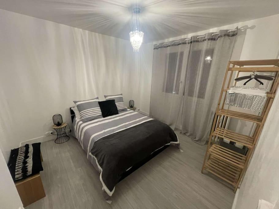 um quarto com uma cama grande num quarto branco em Superbe appartement avec emplacement idéal em Mulhouse